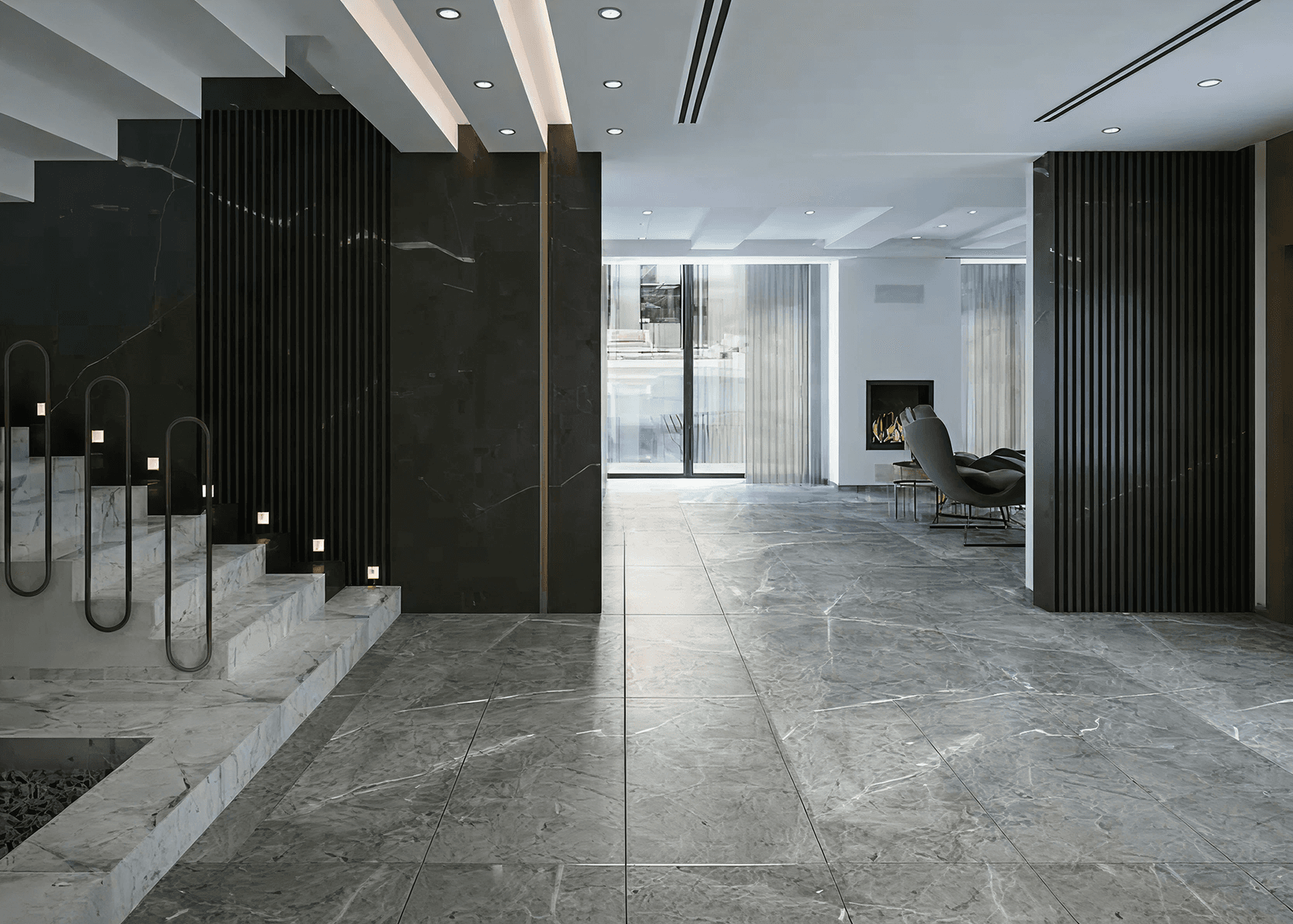 Modern interior with marble floors, elegant staircase, dark wood panels, and cozy seating by a fireplace. Soft lighting and large windows create an inviting ambiance.