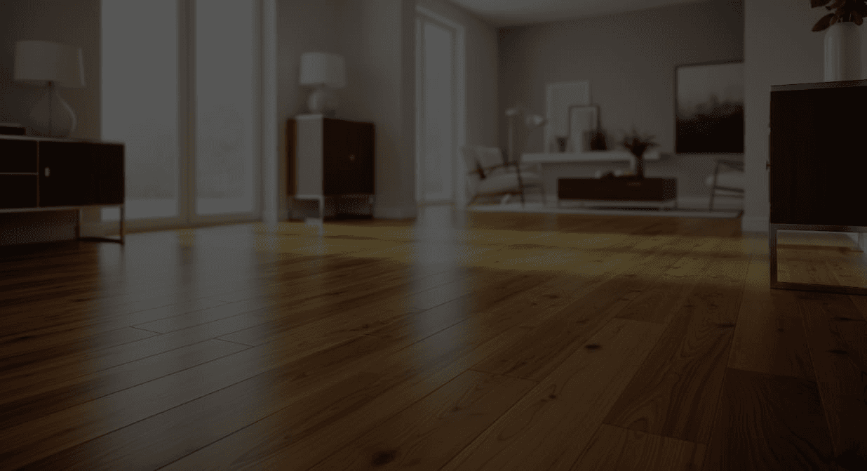 Spacious living room with polished wooden floor, modern furniture, and large windows. Soft natural light creates a calm and inviting atmosphere.