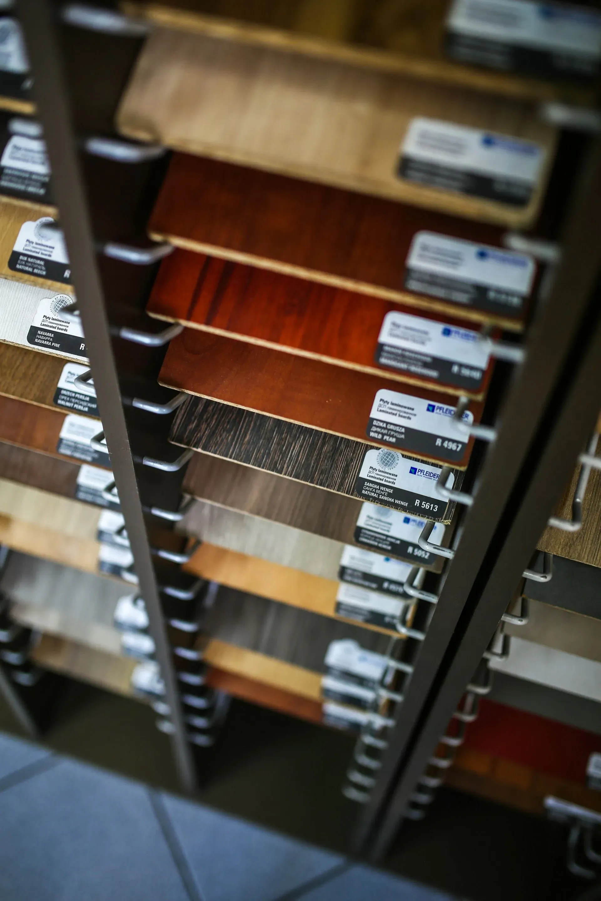 A vertical display of wooden veneer samples in various shades, neatly organized in rows with labels. The image conveys a sense of order and choice.