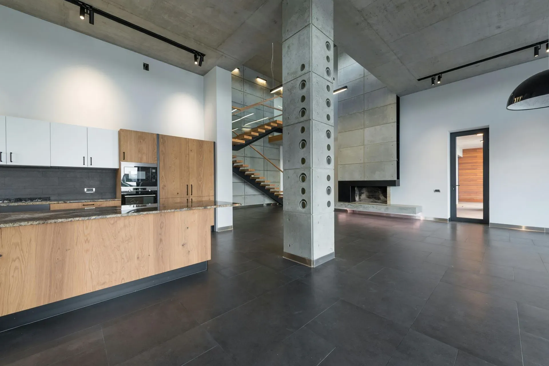 Modern office space with exposed brick walls, large windows, and black-and-white striped rugs.